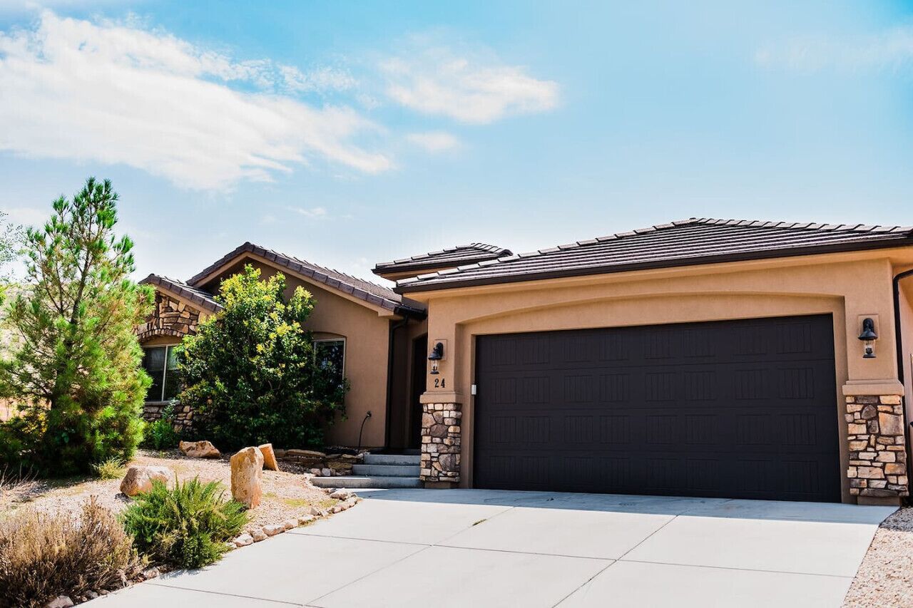 A residential house with a garage, stone accents, and a well-maintained garden.