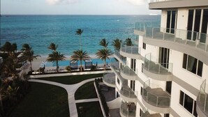 A multi-story hotel with balconies overlooking a beach and the ocean. - One Cable Beach (Nassau)
