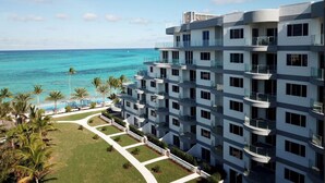 A multi-story hotel with balconies overlooking a beach and ocean. - One Cable Beach (Nassau)