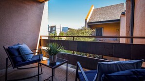 Een balkon met een bank, een kleine tafel en een bloempot.