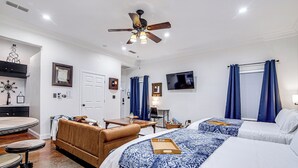A hotel room with two beds, a ceiling fan, a TV, and a desk with a chair. - Old Town Rodeo Studio. Free parking. Walk to entertainment and restaurants. (Burleson)