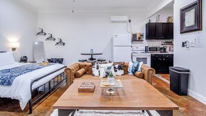 A compact living space with a bed, sofa, dining table, and kitchenette. - Old Town Rodeo Studio. Free parking. Walk to entertainment and restaurants. (Burleson)