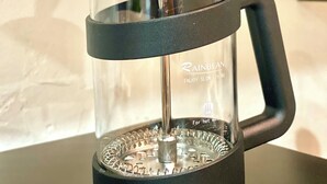 A French press coffee maker with a black handle and lid, placed on a black surface. - Old Town Rodeo Studio. Free parking. Walk to entertainment and restaurants. (Burleson)