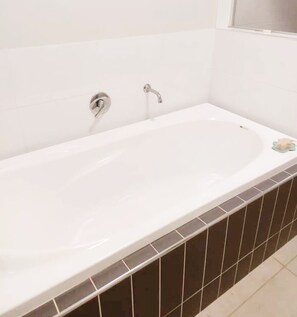 Bathroom features a large bathtub and a single faucet.