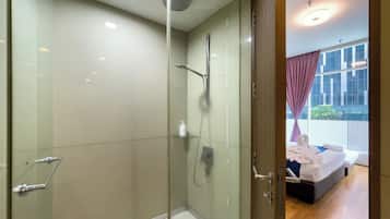 A modern bathroom with a glass-enclosed shower, a glass door, and a visible towel rack.