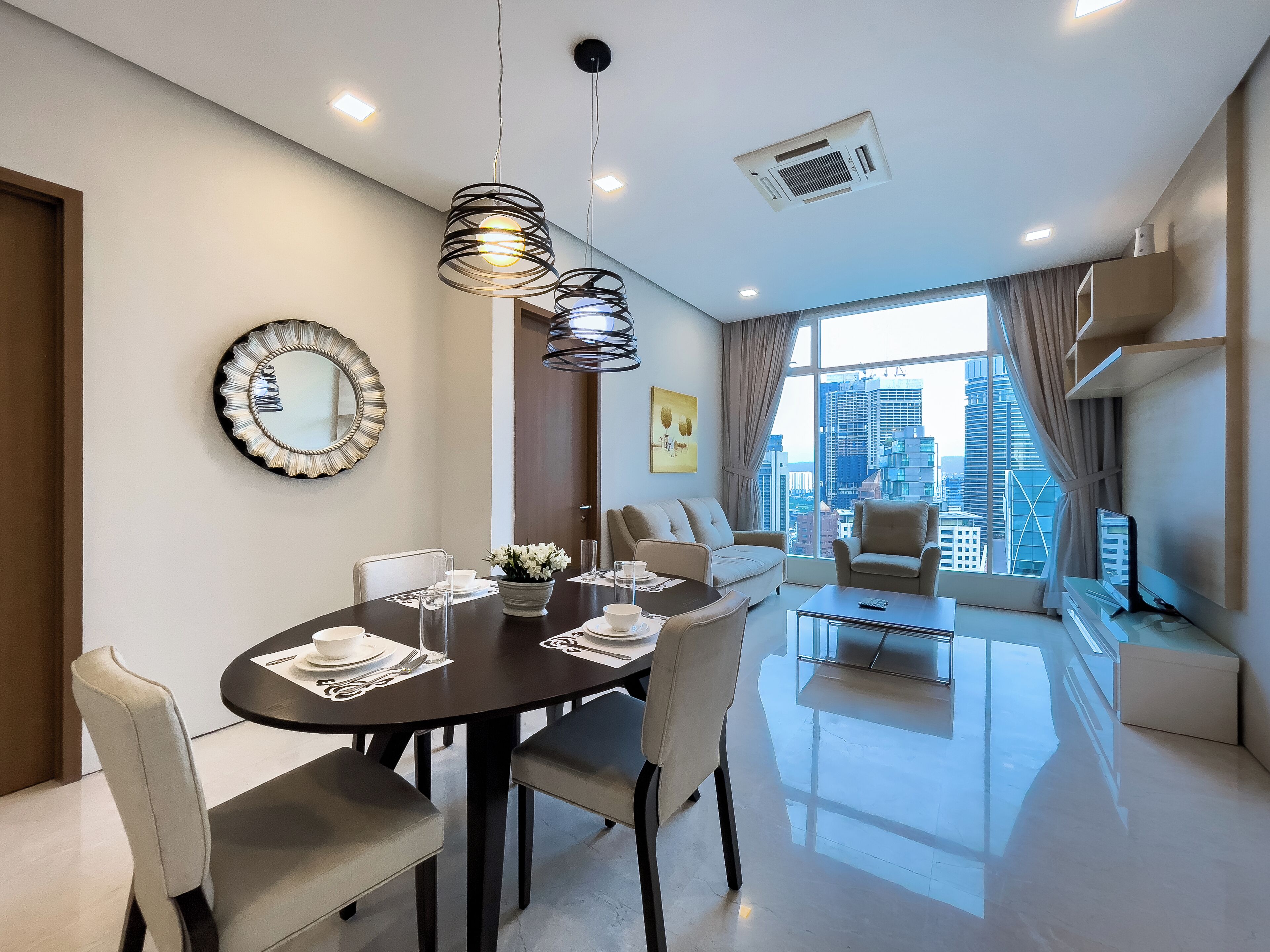 Un salon moderne avec un coin repas, comprenant un canapé, des fauteuils, une table basse et une table à manger pour quatre personnes.