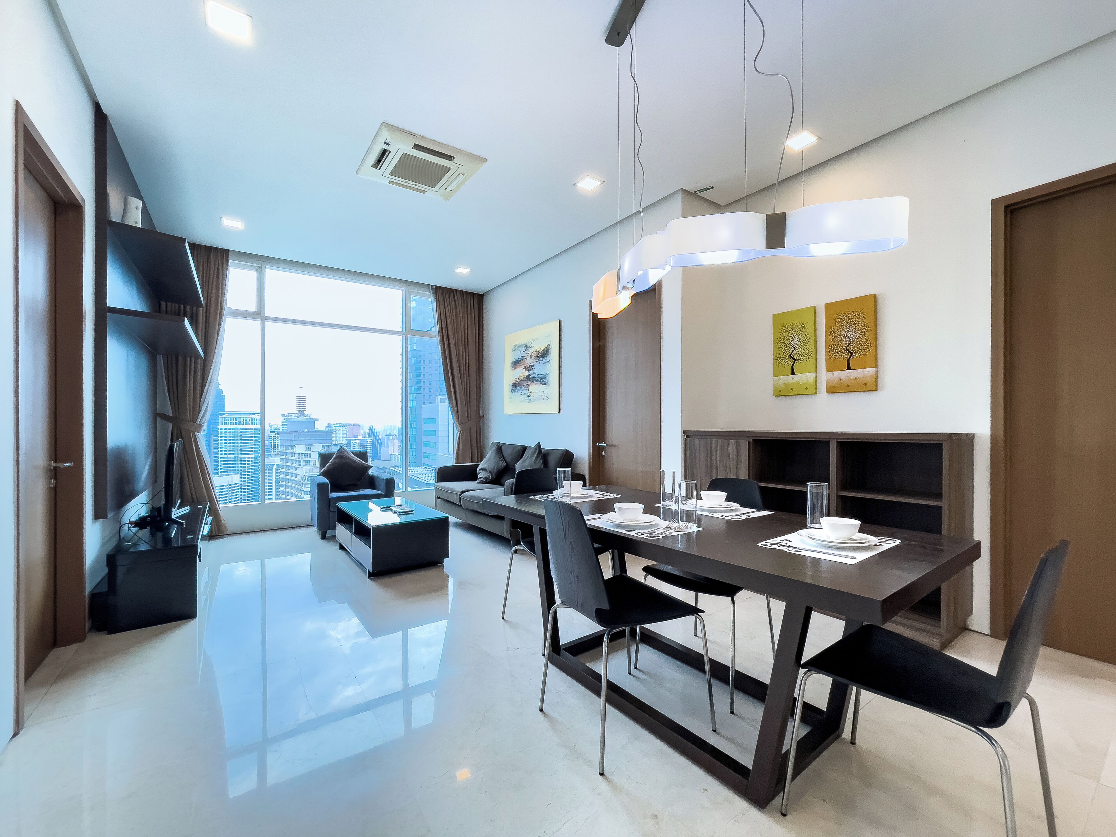 Un salon moderne avec un coin repas, de grandes fenêtres et une vue sur la ville.