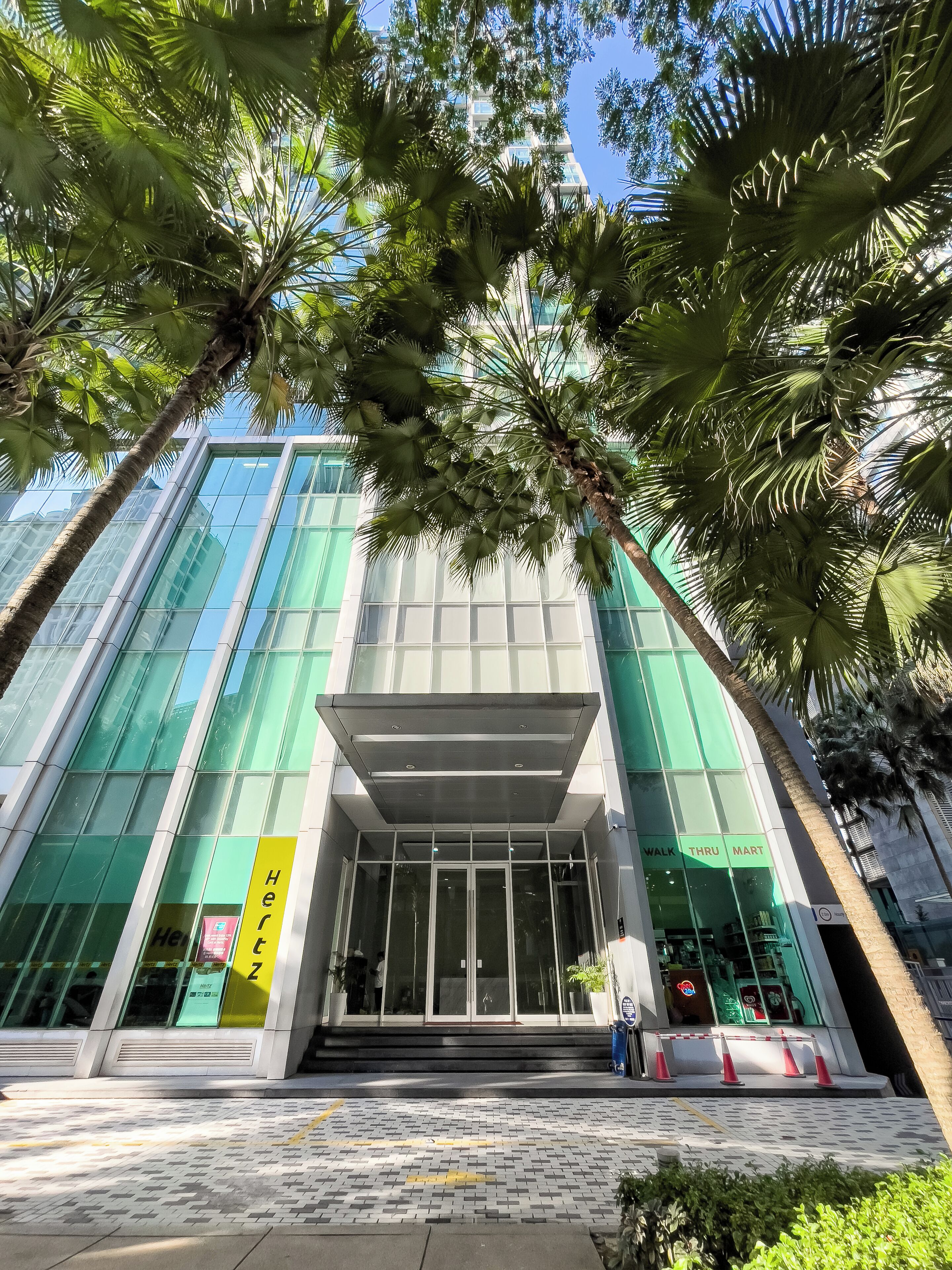 A modern building with large glass windows, a covered entrance, and a sign for 'Walk Thru Mart'.
