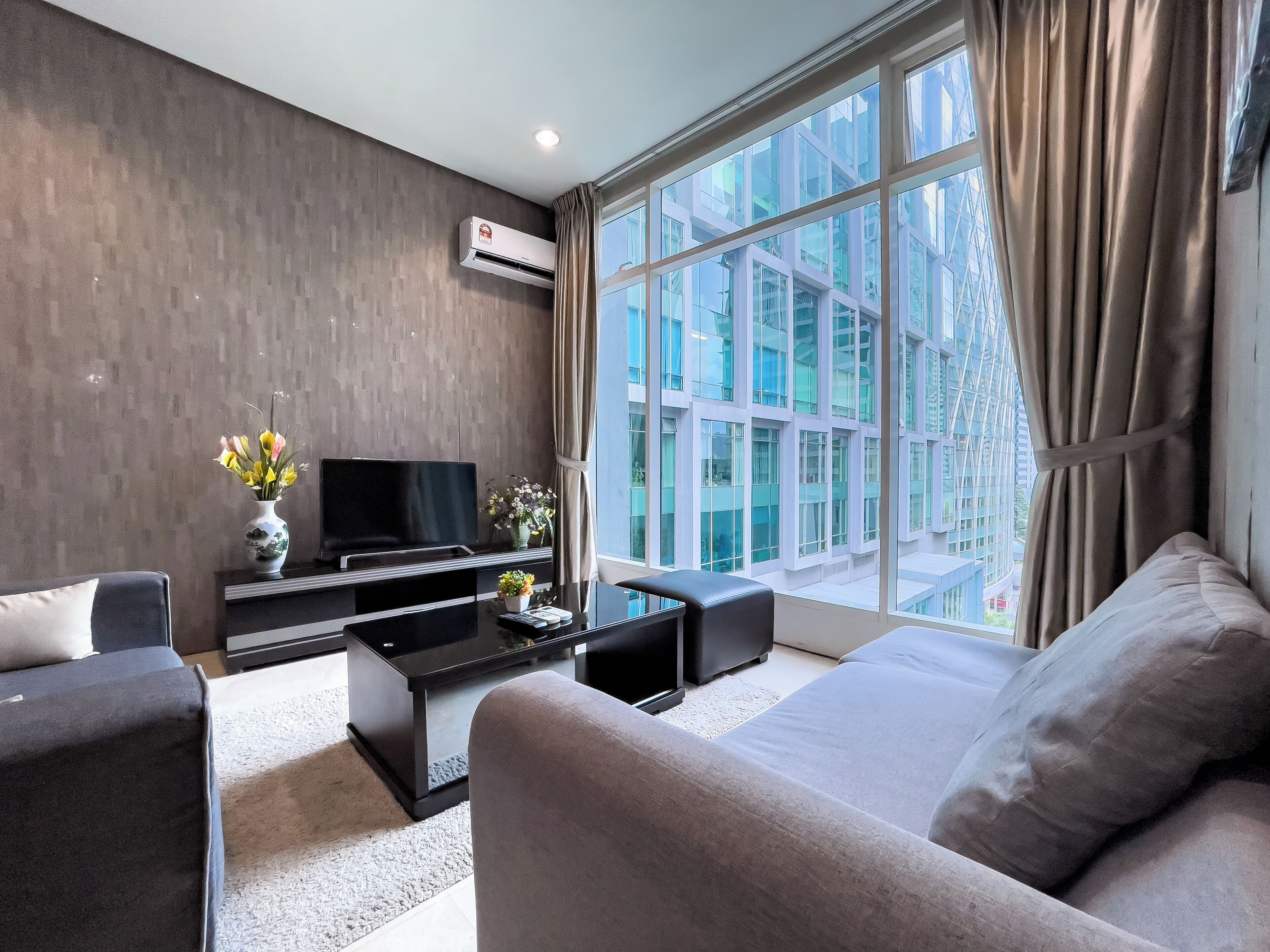 A modern living room with a flat-screen TV, sofa, and coffee table.