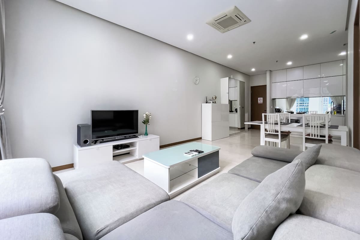 Un salon moderne avec un téléviseur à écran plat, une table basse et un canapé.