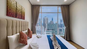 A hotel room with a large bed, a view of the cityscape, and a modern design.