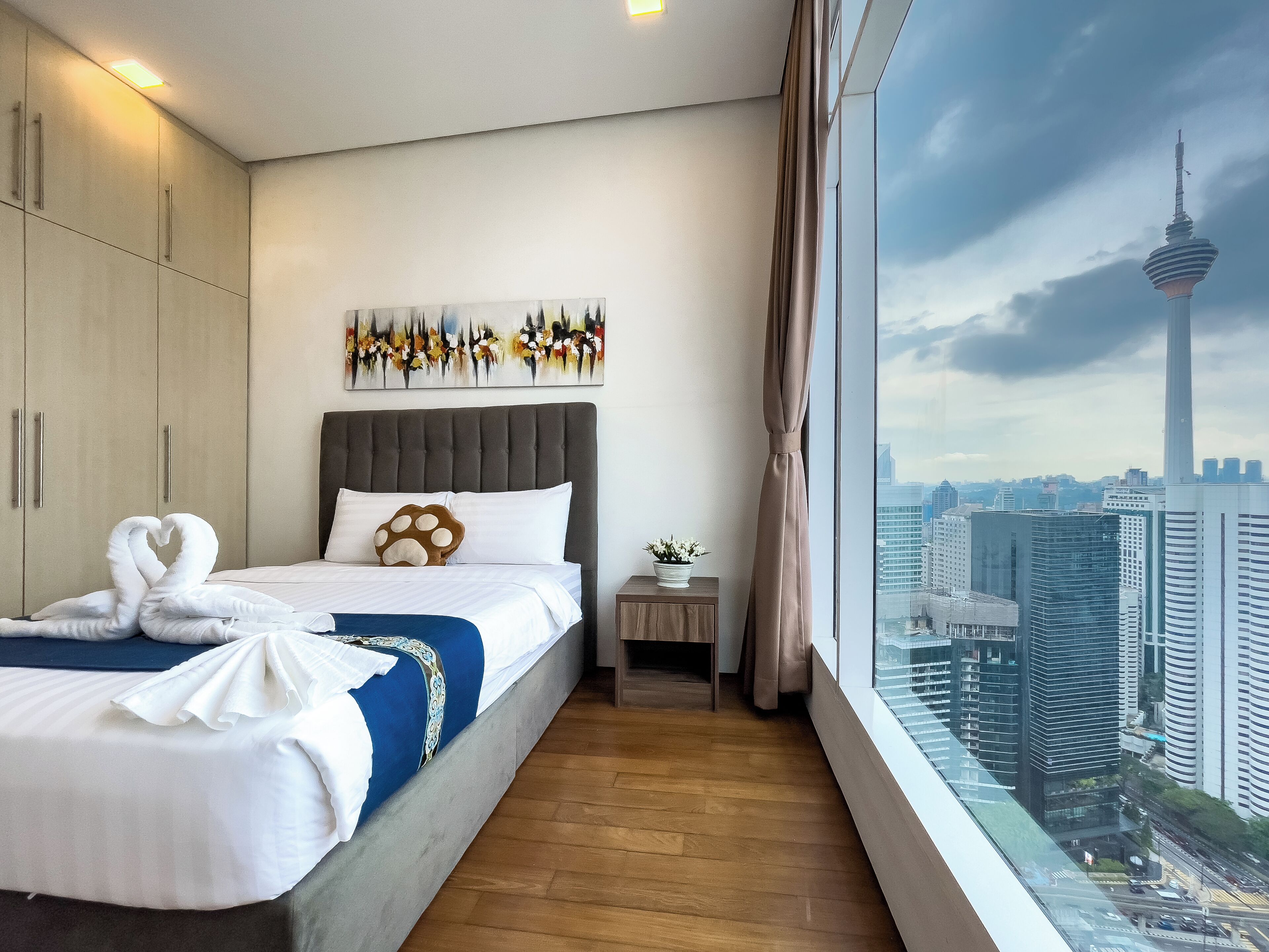 Een moderne hotelkamer met een groot bed, stadszicht en uitzicht op de toren.