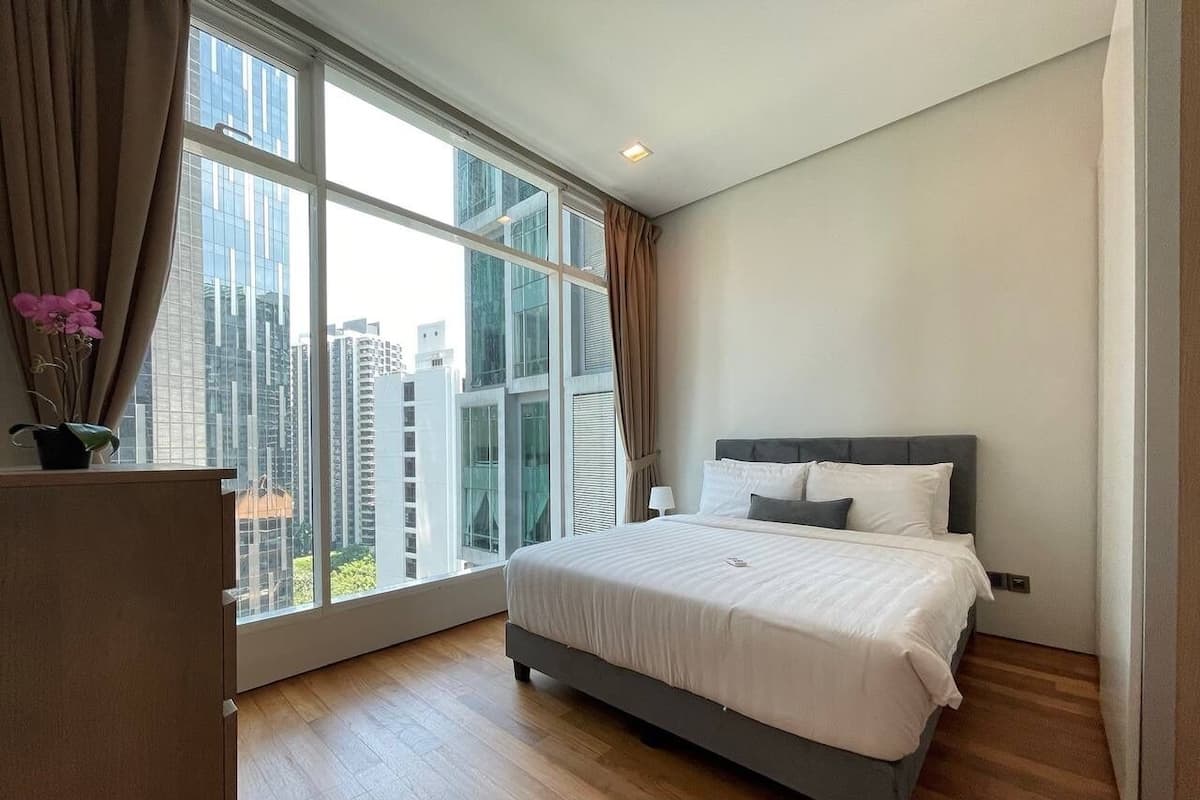 Une chambre à coucher moderne avec une grande fenêtre, un lit et un bureau.