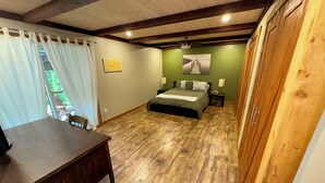 A bedroom with a wooden floor, a bed, a desk, and a window with curtains. - Reenie’s Rustic Retreat - Walking distance to beach, Pet friendly!  (Swansea Point)