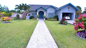 Une maison à deux étages avec une entrée à l’avant, une allée et un garage.