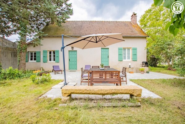 A house with a patio, outdoor seating, and a table.