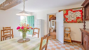 A dining area with a table set for two, a vase of flowers, and a map on the wall. - Le Petit Chambi - CHAMBILLY (CHAMBILLY)