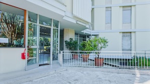 A modern building with a glass entrance, potted plants, and a stone-paved courtyard. - Imperatrice apartment by Wonderful Italy (Sanremo)