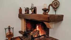 Una chimenea con detalles de ladrillo, un reloj y elementos decorativos en el repisa.