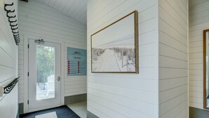 Un couloir avec une porte, un tableau encadré et un panneau sur le mur.