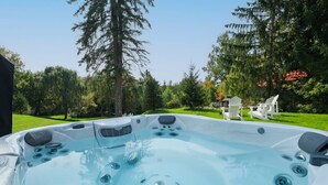 Een whirlpool met meerdere jets, omringd door grasvelden en bomen.