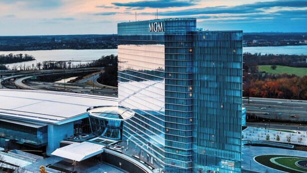 A modern building with a prominent 'MGM' sign, surrounded by a landscaped area and a body of water.