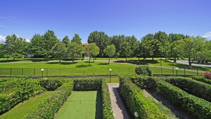 A well-maintained park with manicured lawns, hedges, and trees.
