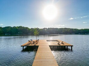 A wooden dock extending into calm water with a clear sky above.