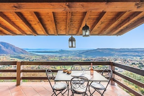A wooden pergola with a table and chairs overlooking a scenic landscape. - Poggio sul Clisi 30 Apartment by Wonderful Italy (Villanuova sul Clisi)