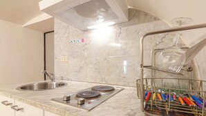 A modern kitchen with a stainless steel sink, a built-in stove, and a dish rack with utensils. - Studio nel Cuore della Citta' by Wonderful Italy (Bologna)