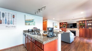 A modern kitchen with granite countertops, wooden cabinets, and a built-in island. - GrandView 303 -2 Bedroom Waterfront condo (Chelan)