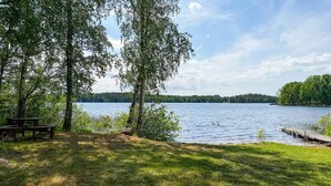 Ein Picknickplatz am Seeufer mit Bänken und einem Steg.