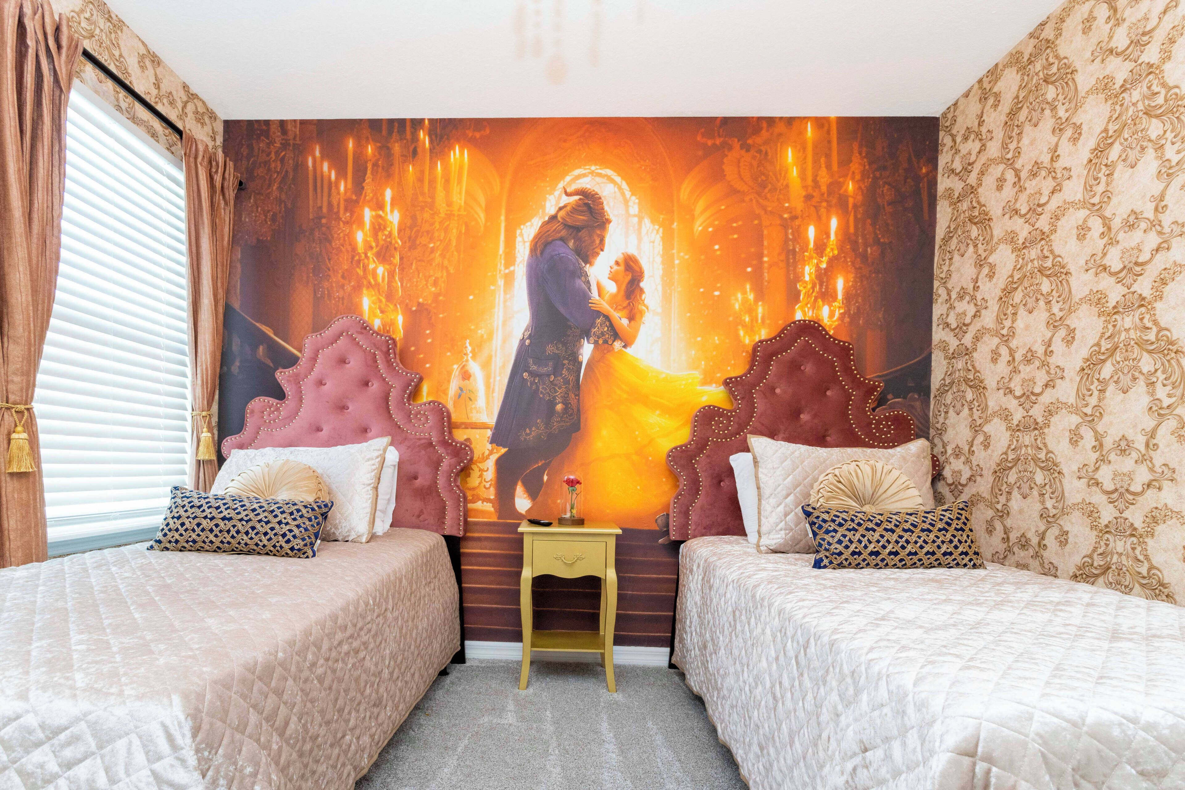 A bedroom with two beds, a mural, and a small table.