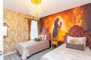 A bedroom with two beds, a chandelier, and a large mural on the wall.