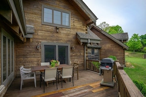 A wooden deck with a barbecue grill, dining table, and chairs. - Mtn Views, Sunsets, WiFi, Fireplace, River & More! (Burnsville)