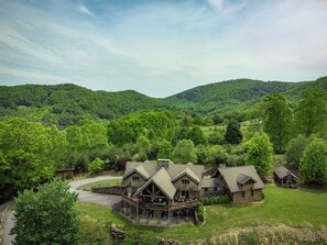 Een lodge met meerdere gebouwen, omgeven door weelderige begroeiing en heuvels.