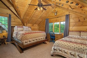 Une cabine équipée de deux lits, d’un bureau et d’un ventilateur de plafond.