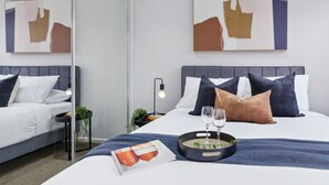 Ein modernes Hotelzimmer mit Bett, Nachttisch und Spiegel.
