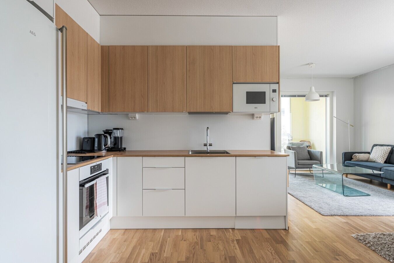 A modern kitchen with wooden cabinets, a microwave, and a coffee maker.