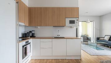 A modern kitchen with wooden cabinets, a microwave, and a coffee maker.