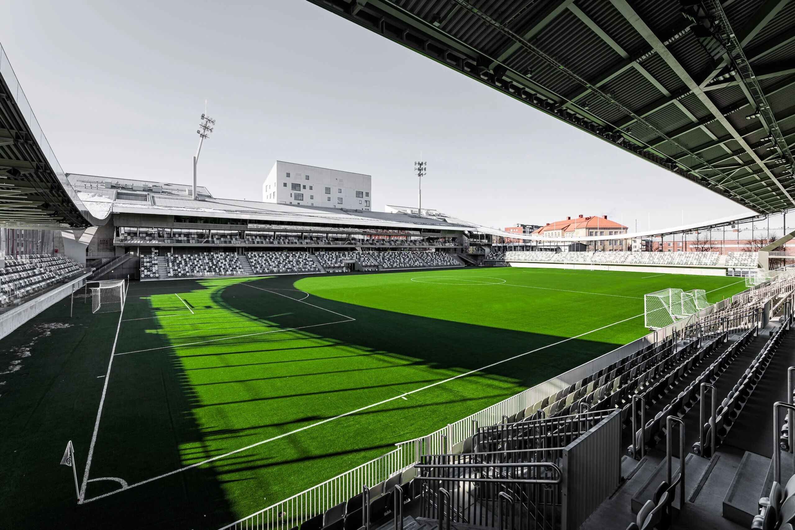 Suuri stadion, jossa on useita kerroksia istumapaikkoja, vihreä pelikenttä ja katettu katsomo.