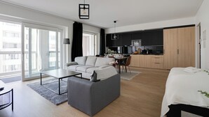 A modern apartment with a living area, dining space, and kitchen. It features a sofa, a dining table, and a kitchen counter. - Vapari - Tampere Soccer Stadium by Come in! (Tampere)