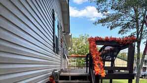 A wooden staircase leading to a porch decorated with autumn leaves and a welcome sign. - Neeley"s Country Suite
 (Walland)