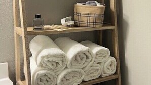 A wooden shelf with rolled white towels, a small potted plant, a basket, and a bicycle. - Neeley"s Country Suite
 (Walland)