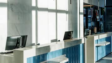 Een modern receptiebalie met een marmeren afwerking, een computer en een telefoon.