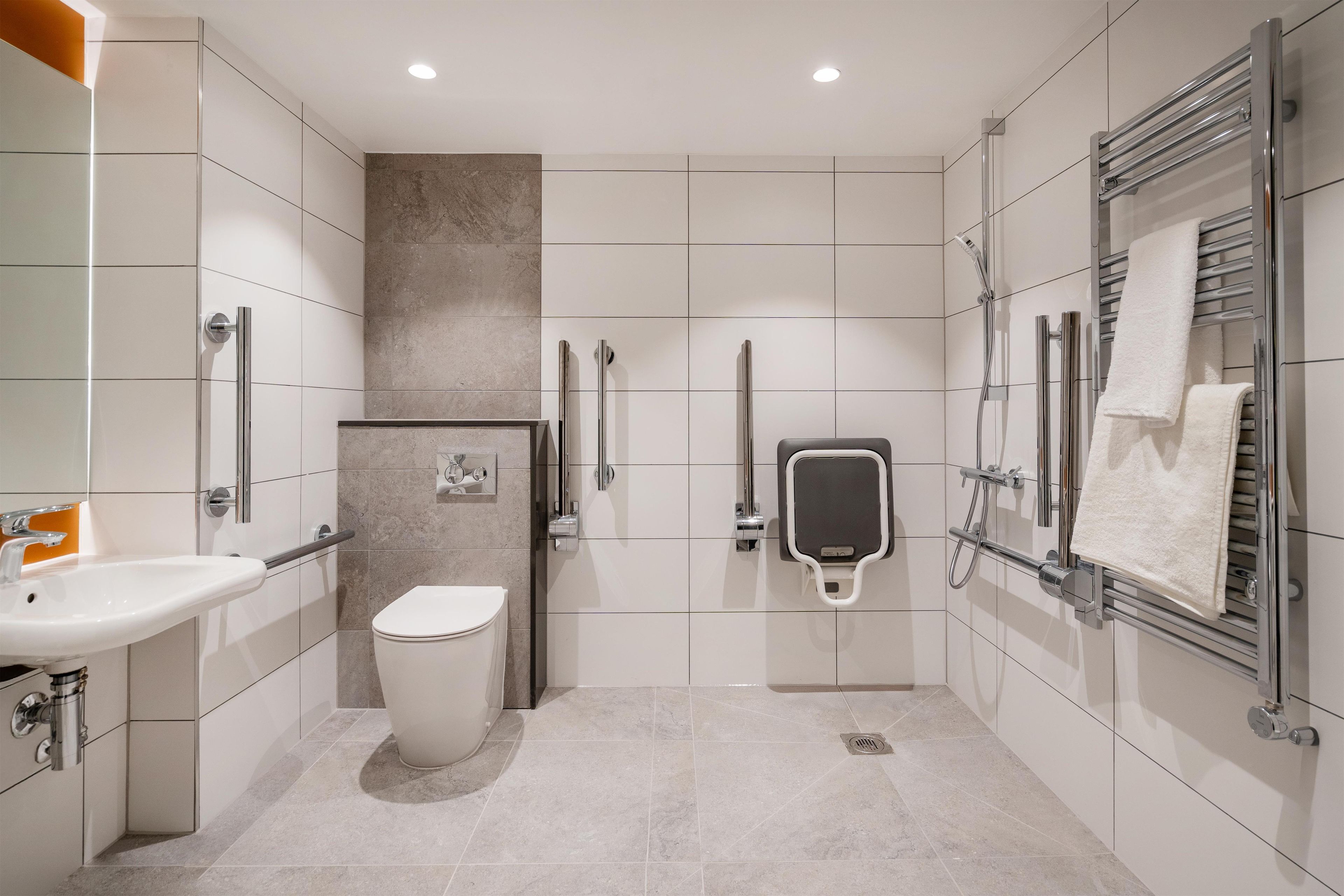 A modern bathroom with a toilet, bidet, and hand dryer.