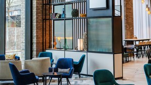 A modern lounge area with seating, a bookshelf, and a 'ZOOM' sign. - Hyatt Place Leeds (Leeds)
