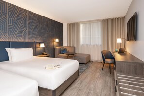 A hotel room with a large bed, a desk with a laptop, a chair, and a sofa. - Hyatt Place Leeds (Leeds)