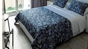 Un dormitorio con una cama grande, ventilador de techo, ventana con cortinas y vista al exterior.