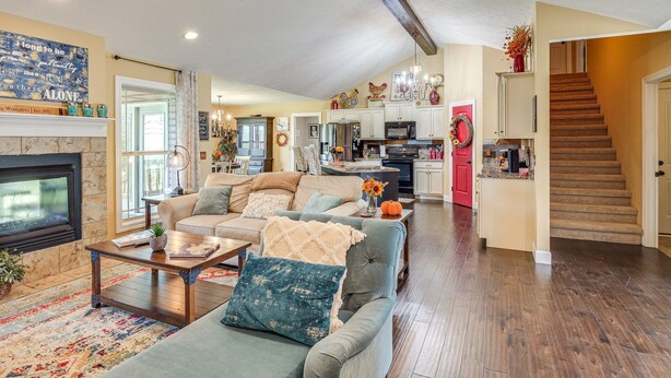 A spacious living room with a fireplace, a dining area, and a kitchen.